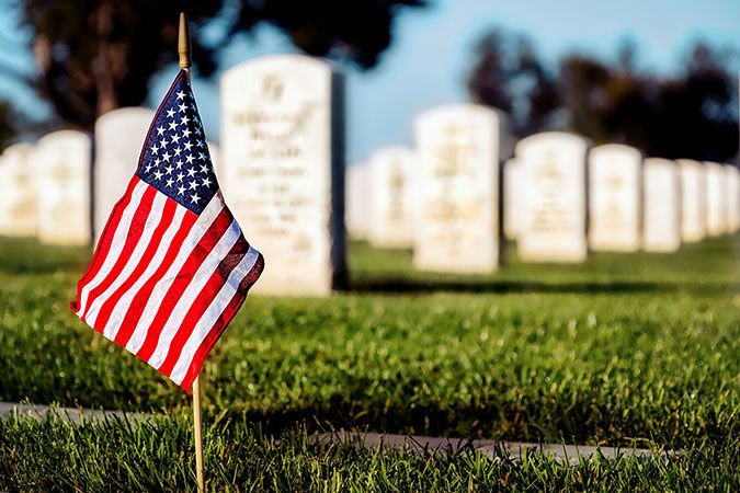 A flag on a grave at a veterans national cemetery.