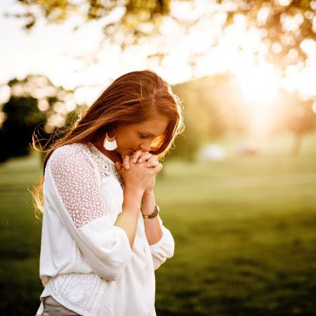 Woman gratefully praying after loved one's body donation